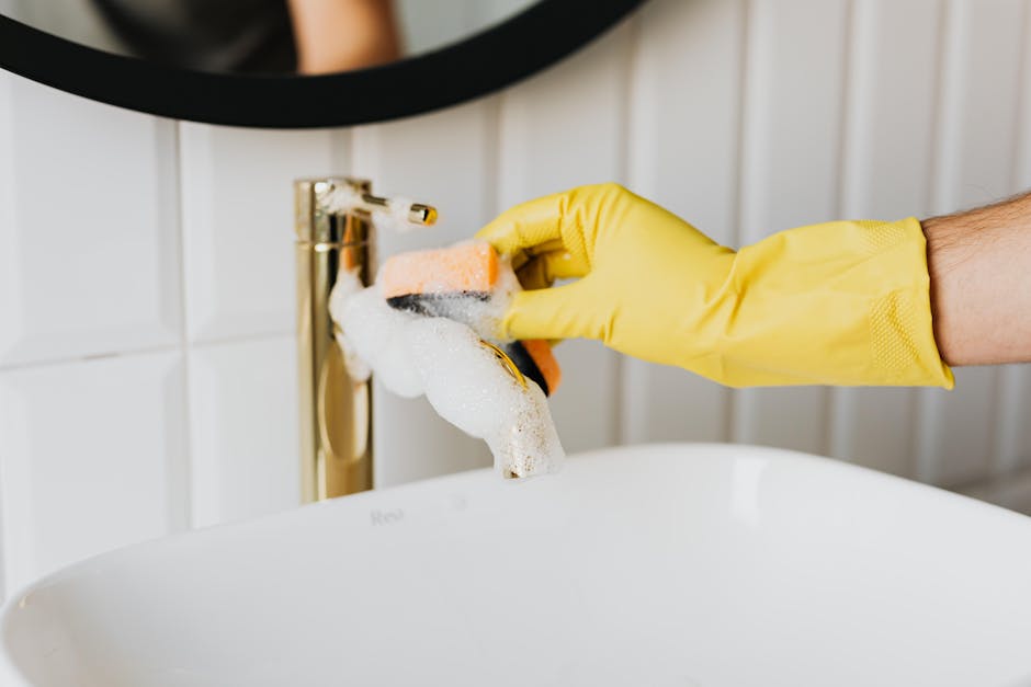 Maid service cleaning bathroom sink